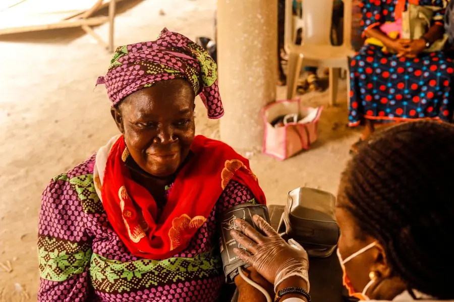A nurse taking an elderly patient's blood pressure at an outreach clinic