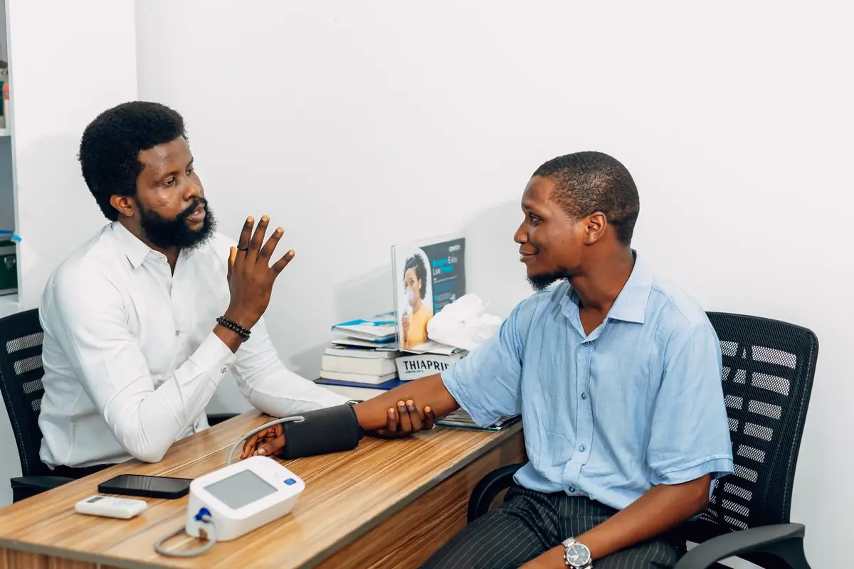 A doctor taking a patient's blood pressure during an outpatient consultation