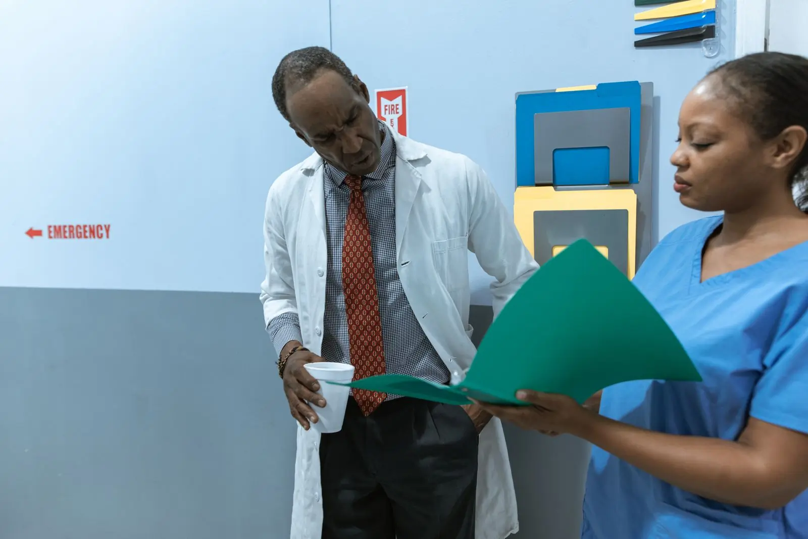 A doctor and a nurse going through the notes on a ward round