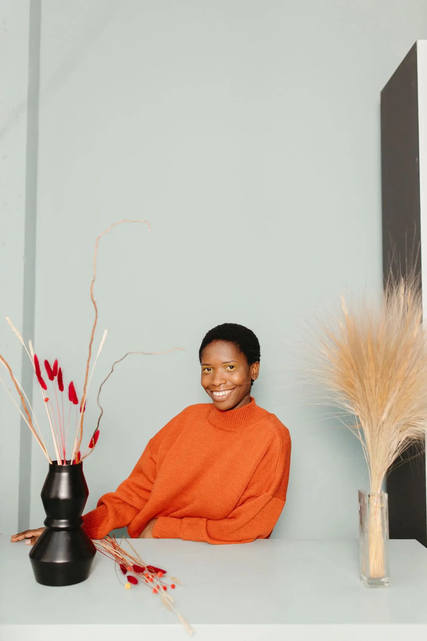 A planner sitting between two vases of dried flowers in the studio