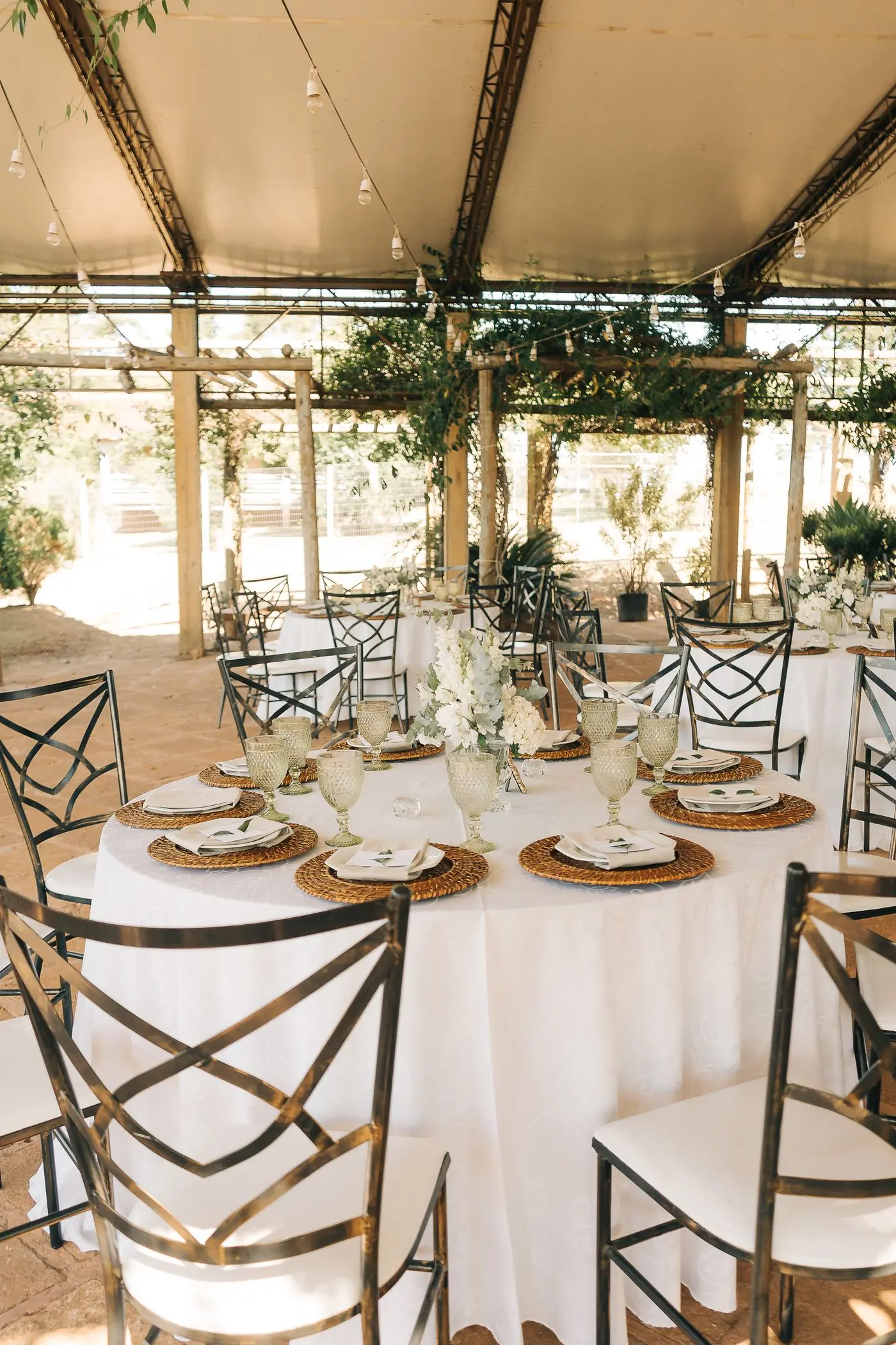 Round tables laid under a marquee before the guests arrive