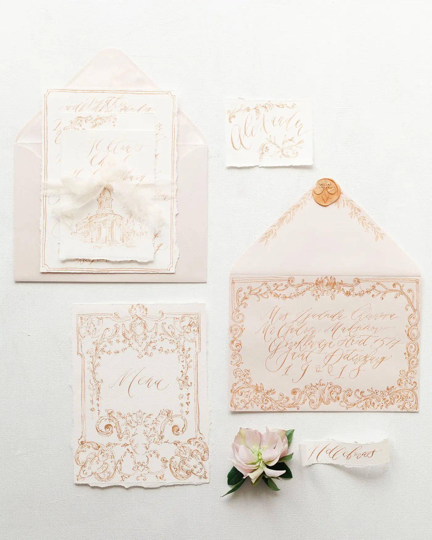 A cream invitation suite with blush envelopes and a wax seal