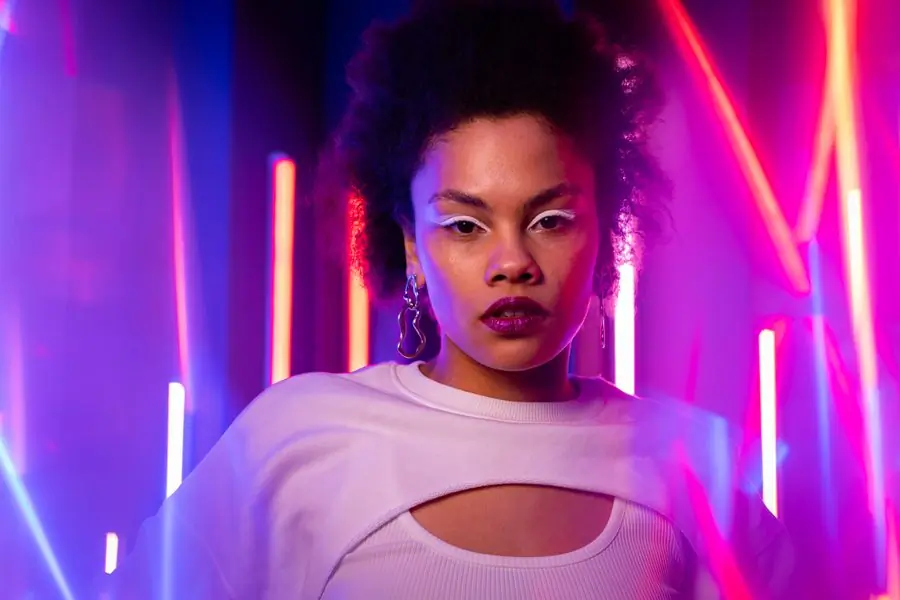 A performer lit by magenta neon tubes
