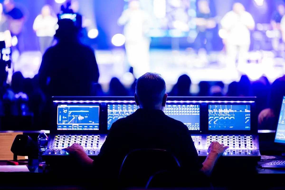 An engineer working a digital mixing console at a live concert