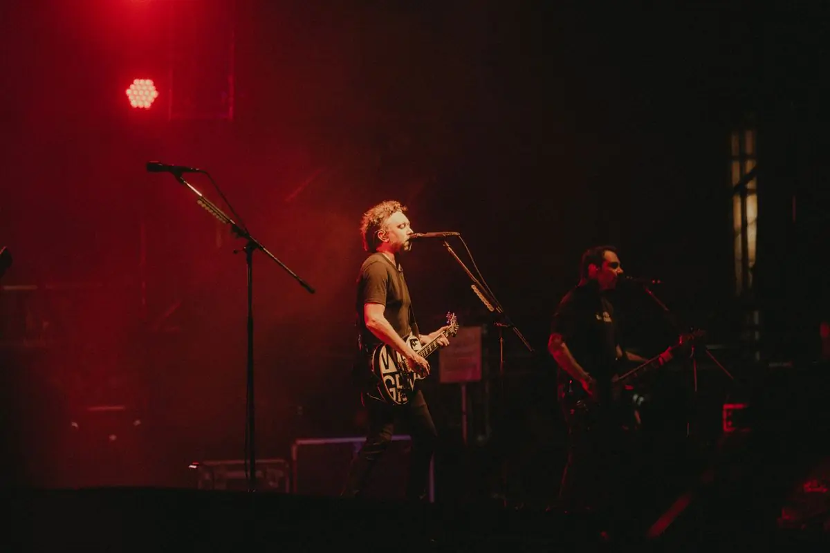 A band performing under deep red stage lighting