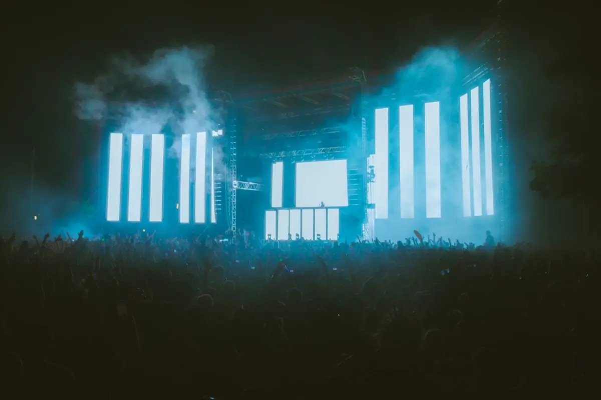 A night crowd in front of large LED screens at a music festival