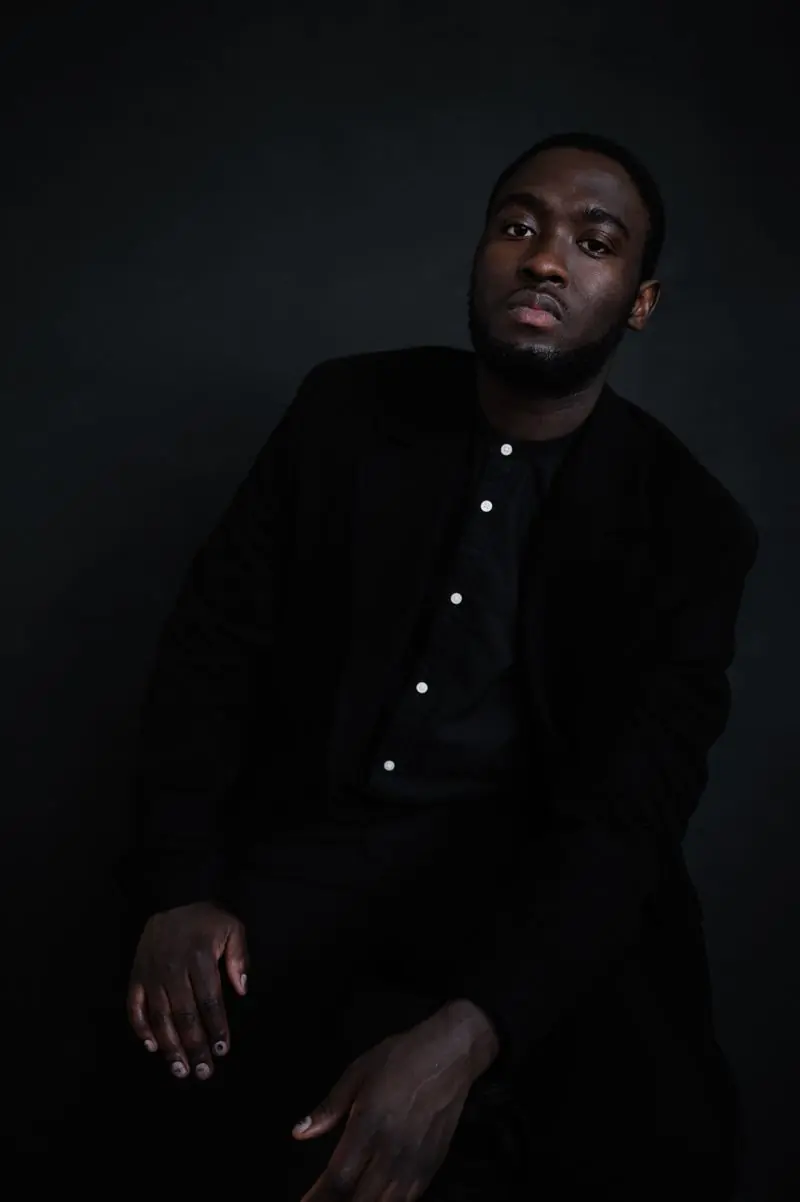 A portrait of a man in a dark suit looking at the camera