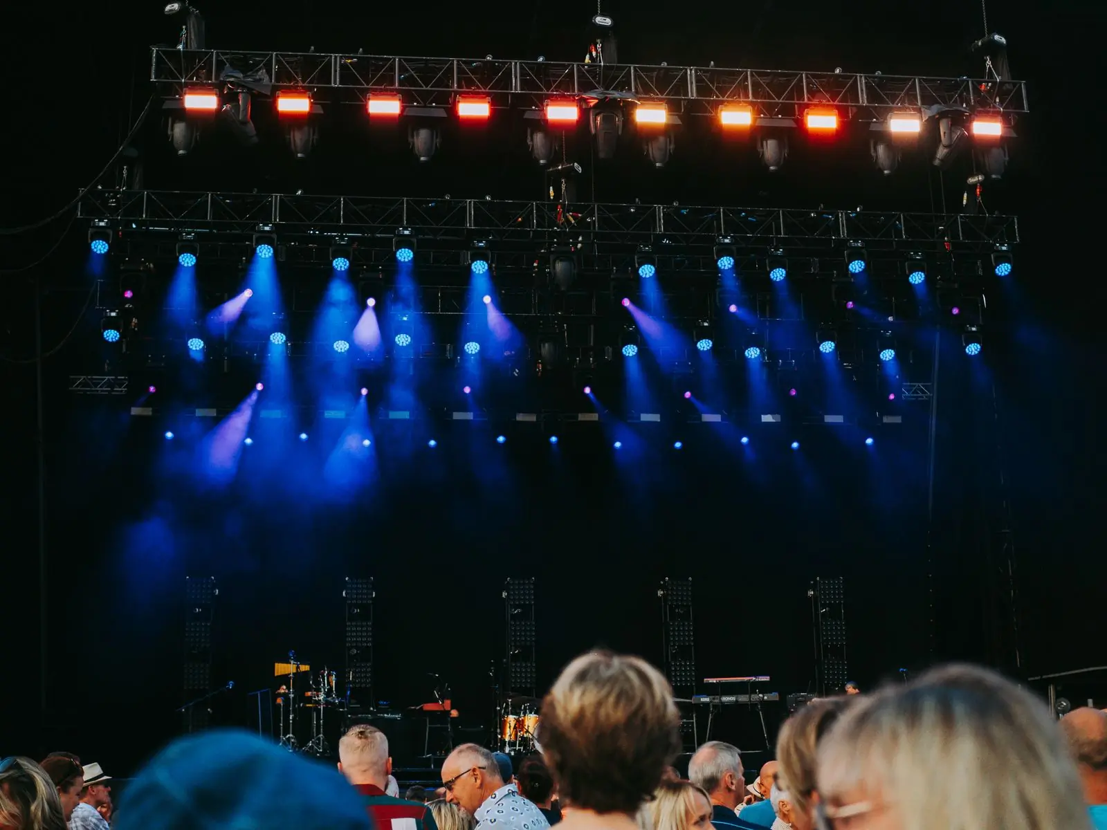 Beams of stage light over a seated audience at a night concert