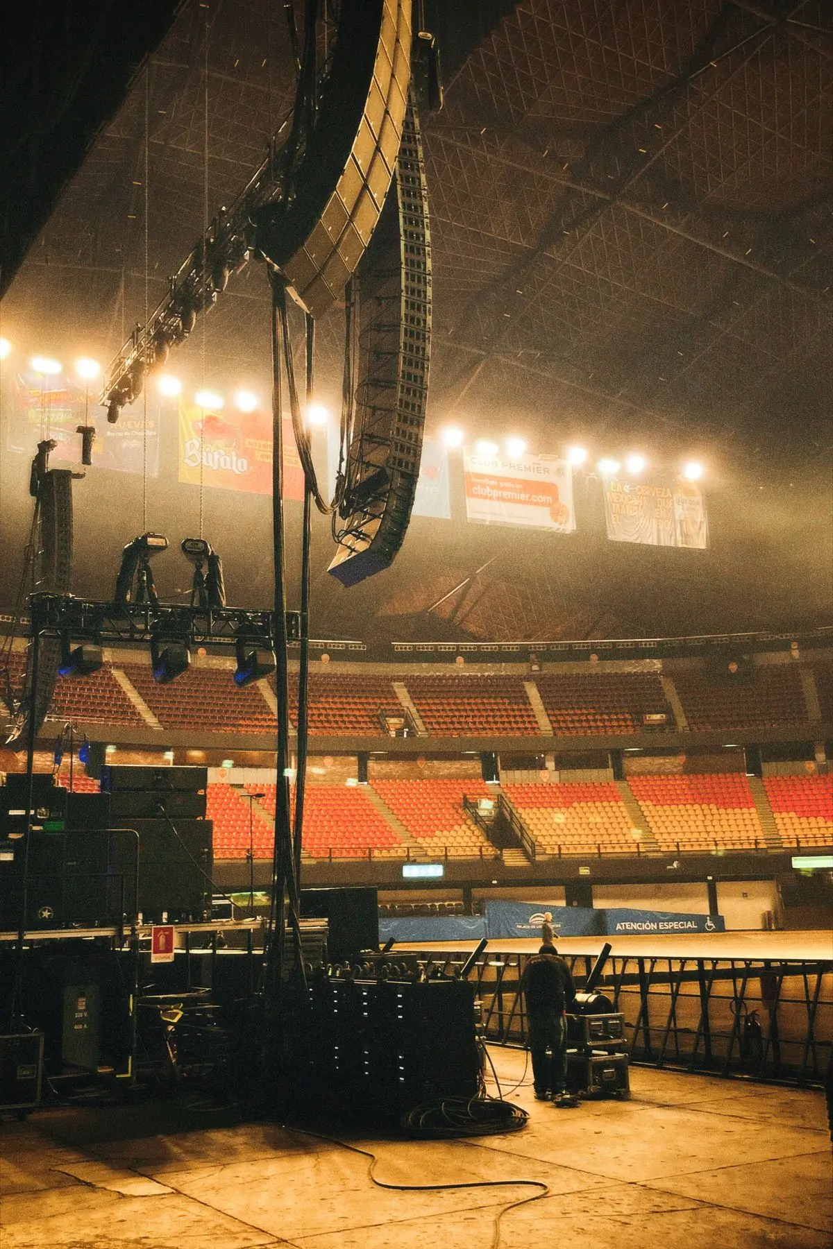 An empty stadium with a stage and lighting rig at one end