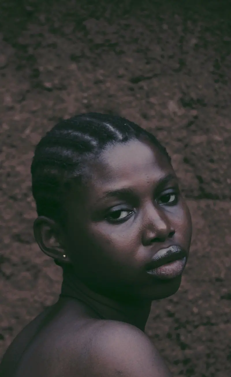 A young woman with a natural hairstyle in a low-lit portrait