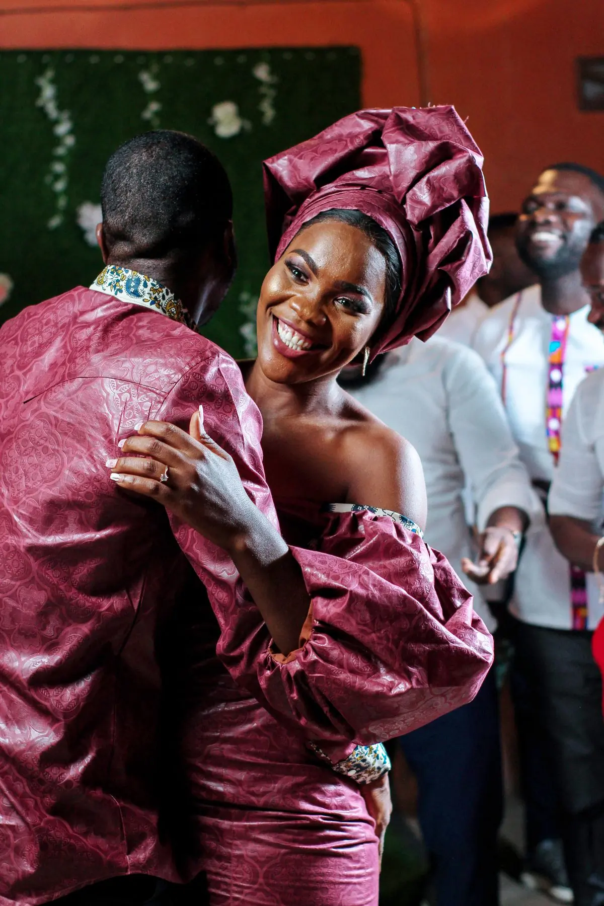 A newly married couple dancing in rose-coloured lace