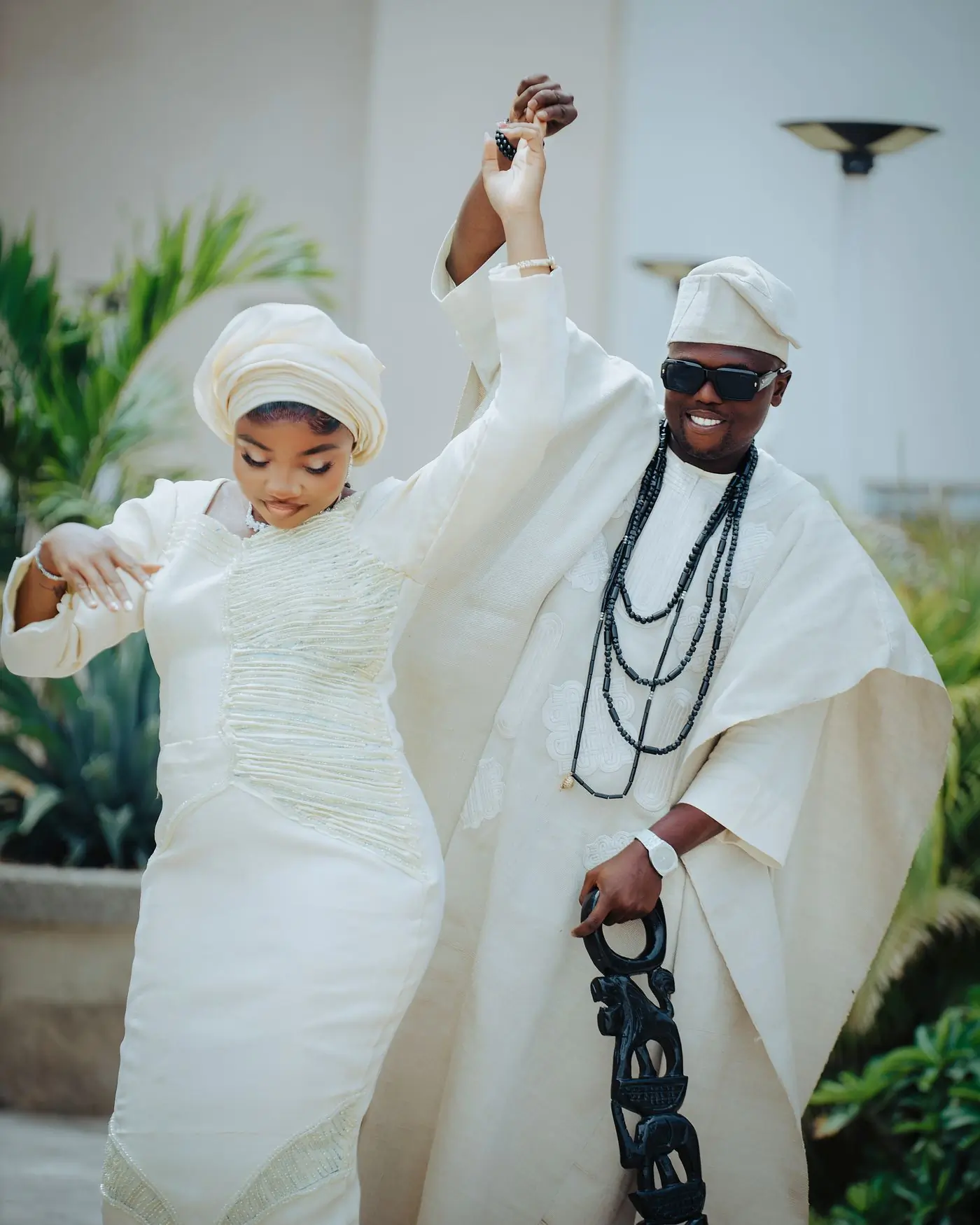 A couple in cream traditional cloth dancing hand in hand