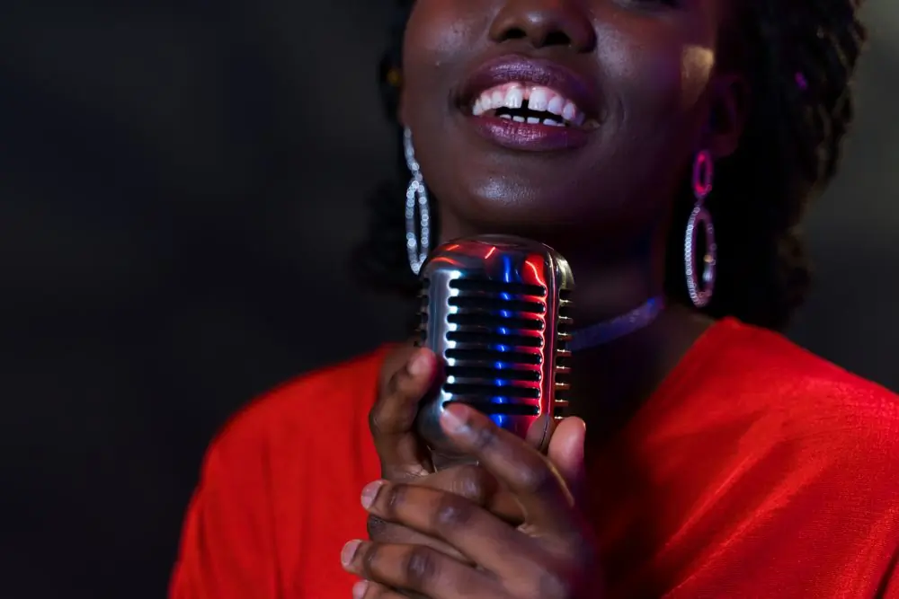 A close view of the artist singing into a chrome microphone