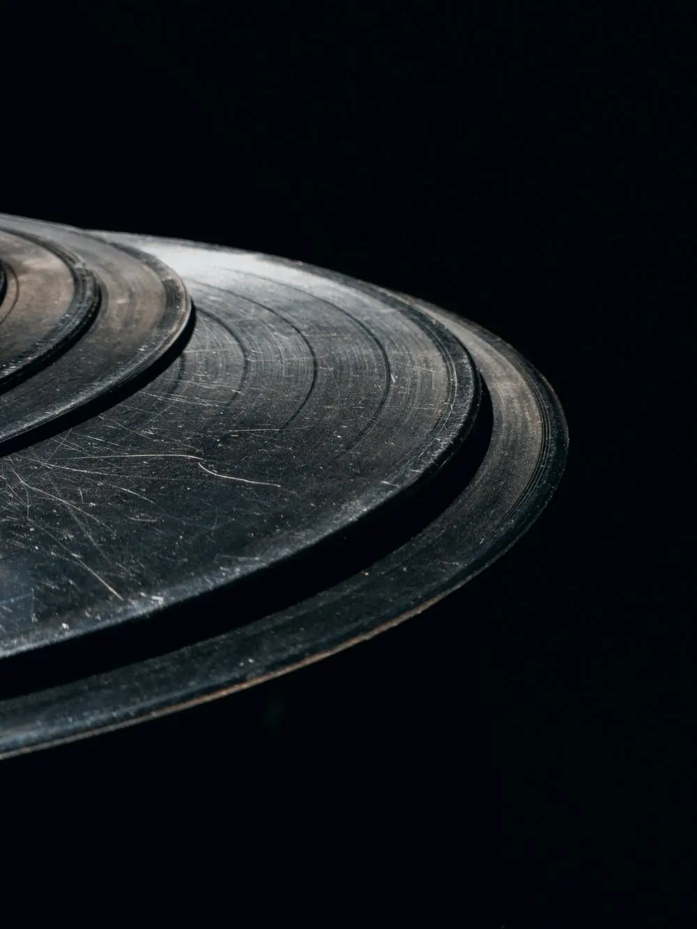 Stacked vintage vinyl records photographed close on black